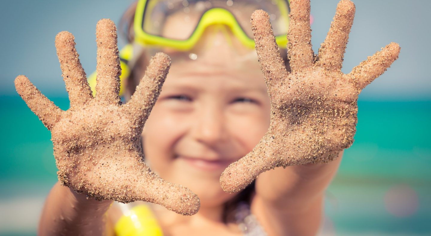 bambino con maschera al mare con sabbia